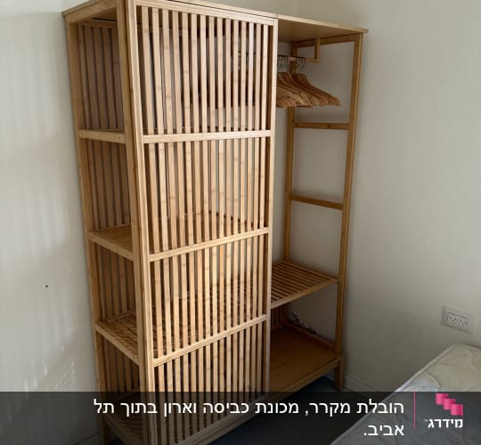 ארון עץ ריק ליד מיטה בחדר ריק
